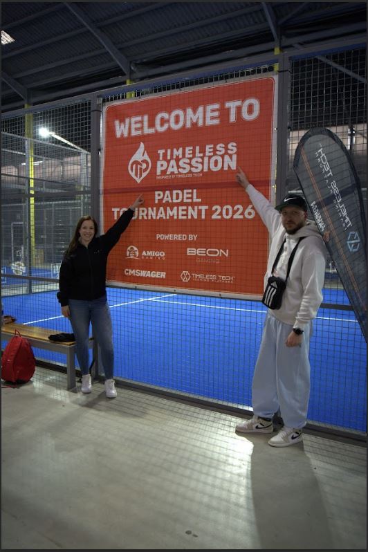 ටයිම්ලෙස් පැෂන් පැඩල් තරඟාවලිය 2026 පිළිගැනීමේ බැනරය අසල සහභාගී වූ දෙදෙනෙකු